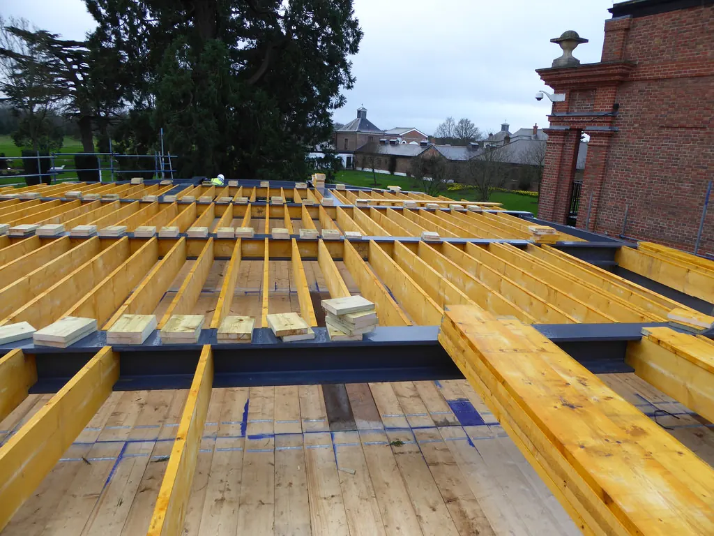 The Grove Hotel Cedar Suite — curved timber roof deck and structural joists, sweeping roof form taking shape