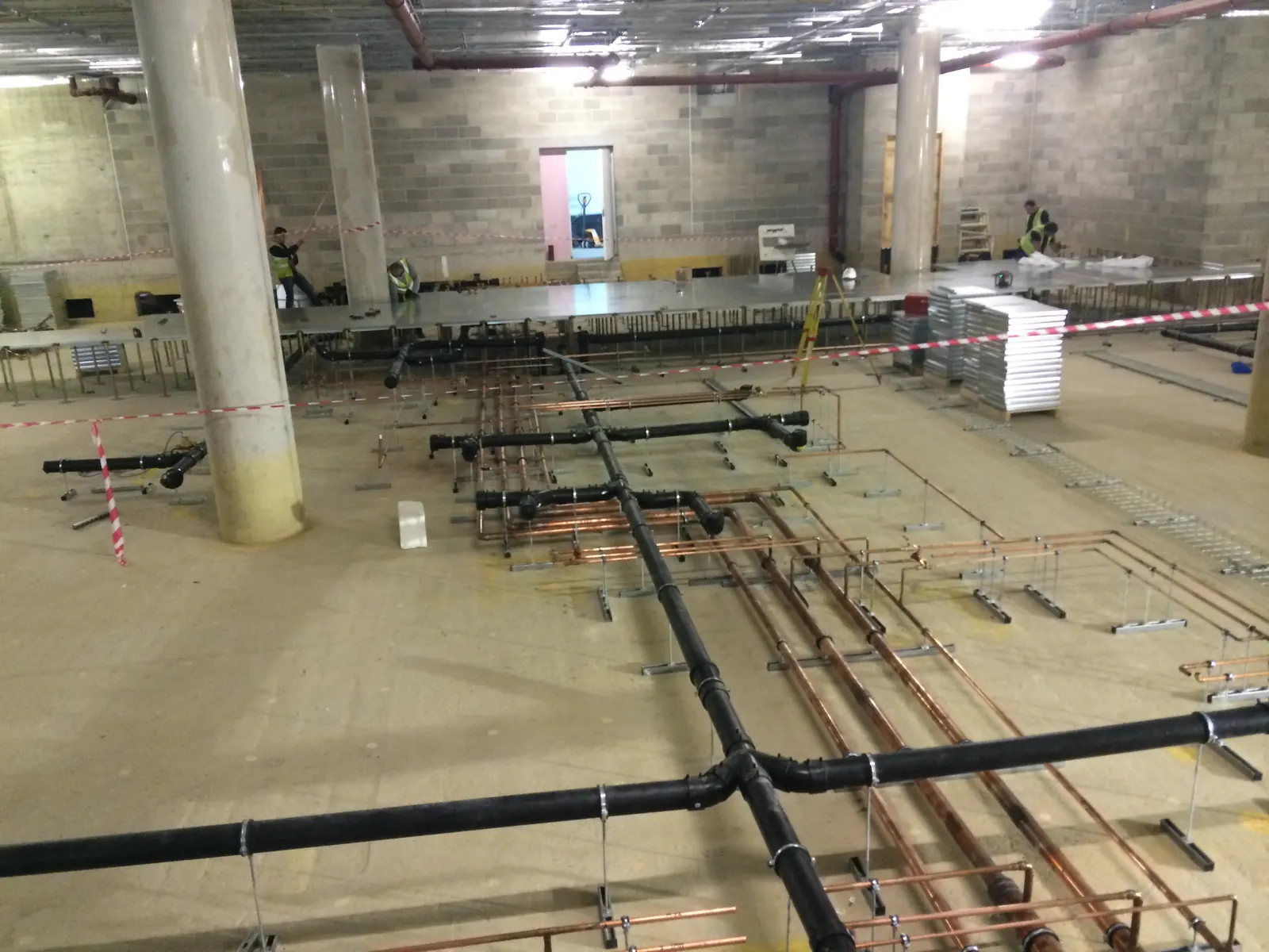 AELTC Wimbledon — basement MEP first-fix installation with raised access flooring infrastructure between Centre Court and Court No.1