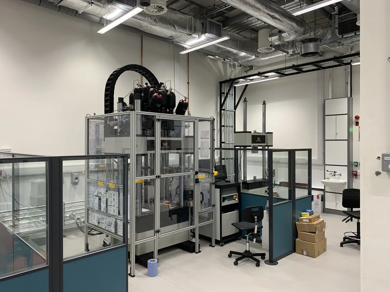 Advanced Materials Testing Facility — Instron universal testing machine in enclosed precision laboratory environment