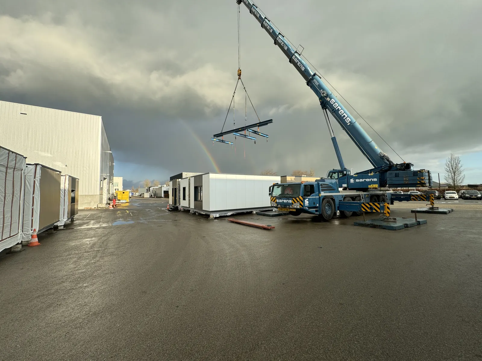 Craig Garbutt — MMC site delivery: crane lifting a spreader beam into position to receive an incoming volumetric unit