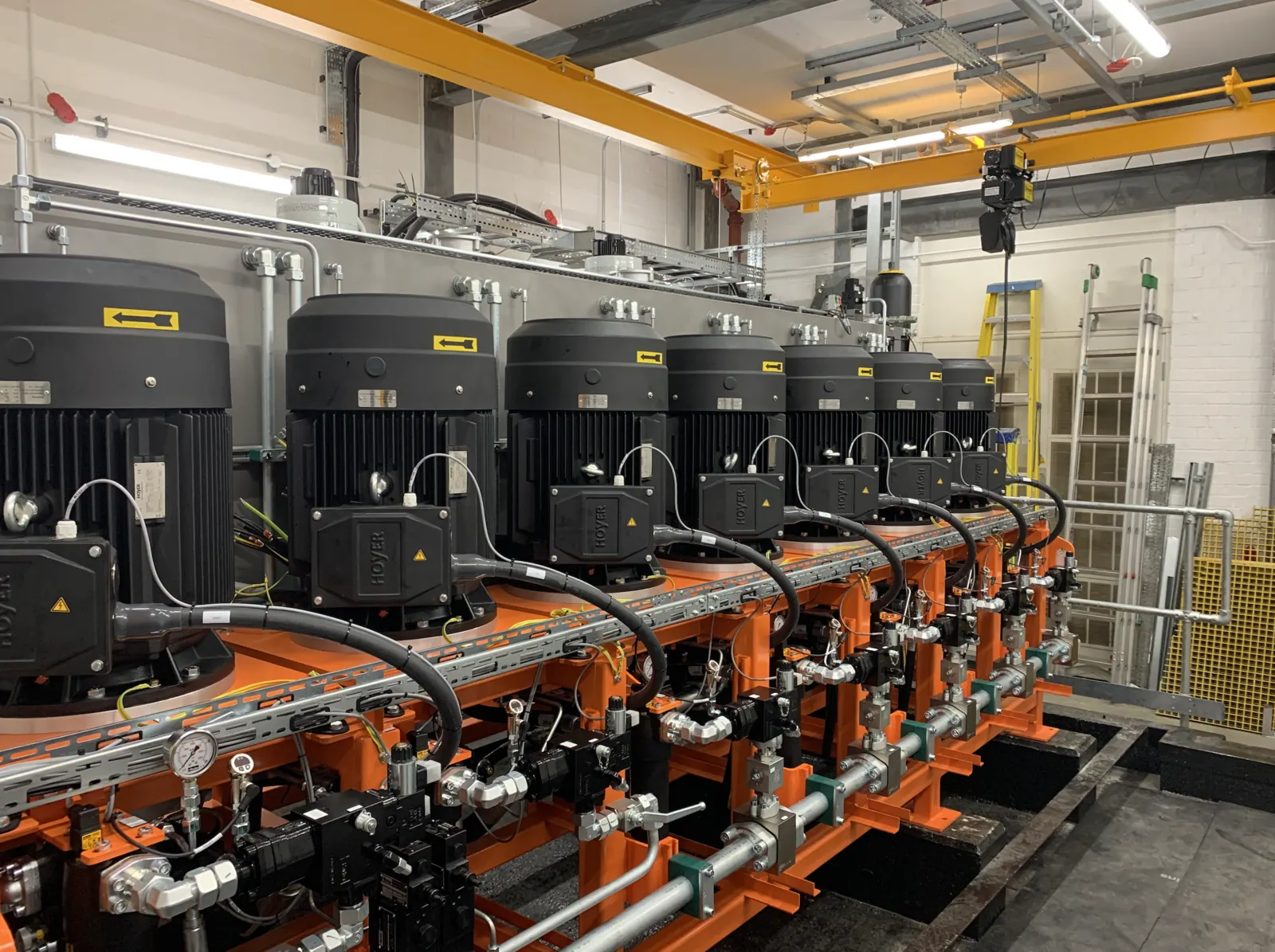 Bank of hydraulic power units in a newly built £23M dedicated hydraulic plant room, engineered to feed several Instron materials-testing machines at a government science and research facility