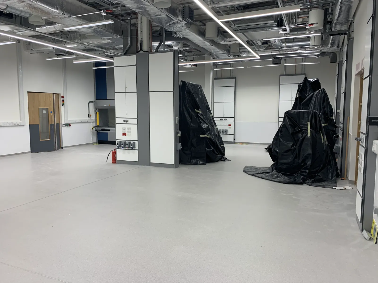 Advanced Materials Testing Facility — testing equipment sheeted for protection with services installation overhead