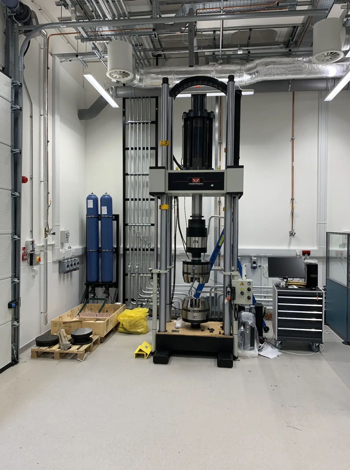 Dedicated hydraulic plant room — Instron testing machine connected to the plant room's hydraulic supply, with gas accumulators alongside