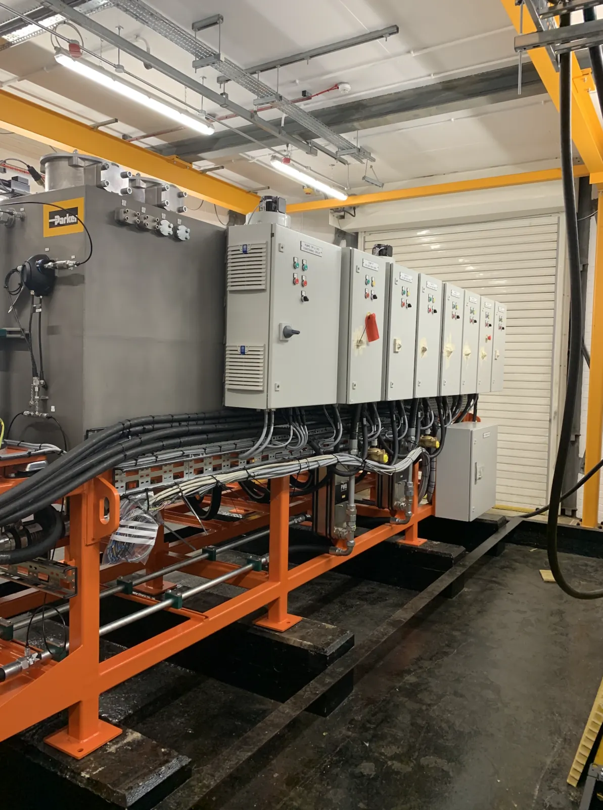 Row of control panels and cabling first-fix along the hydraulic power unit skid